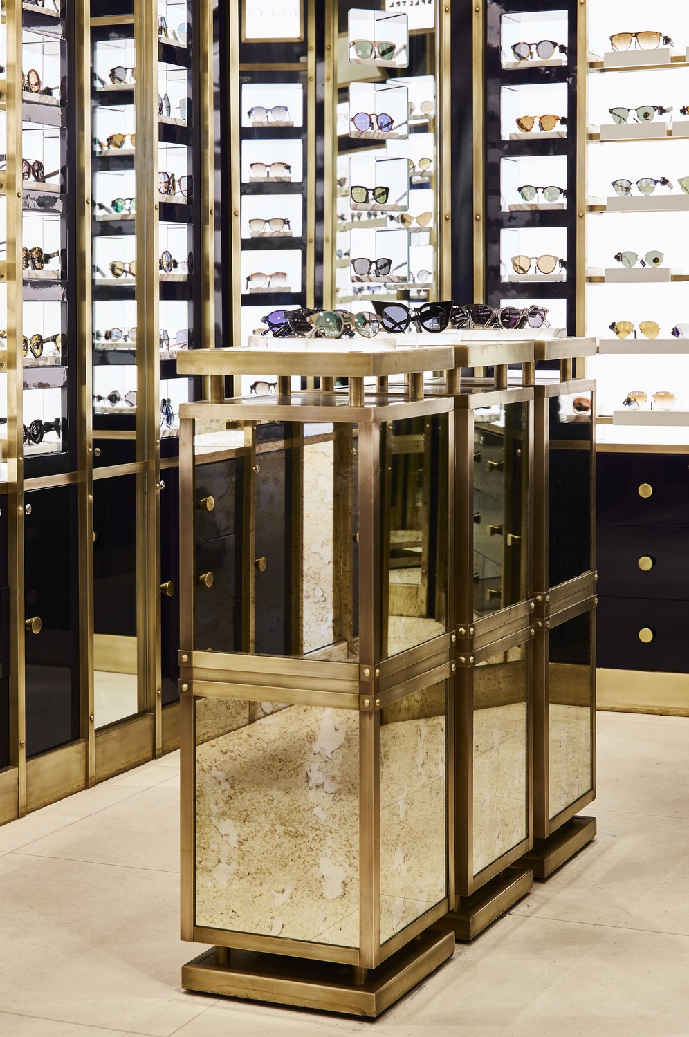Freestanding table display with mirrored panels and brass edges