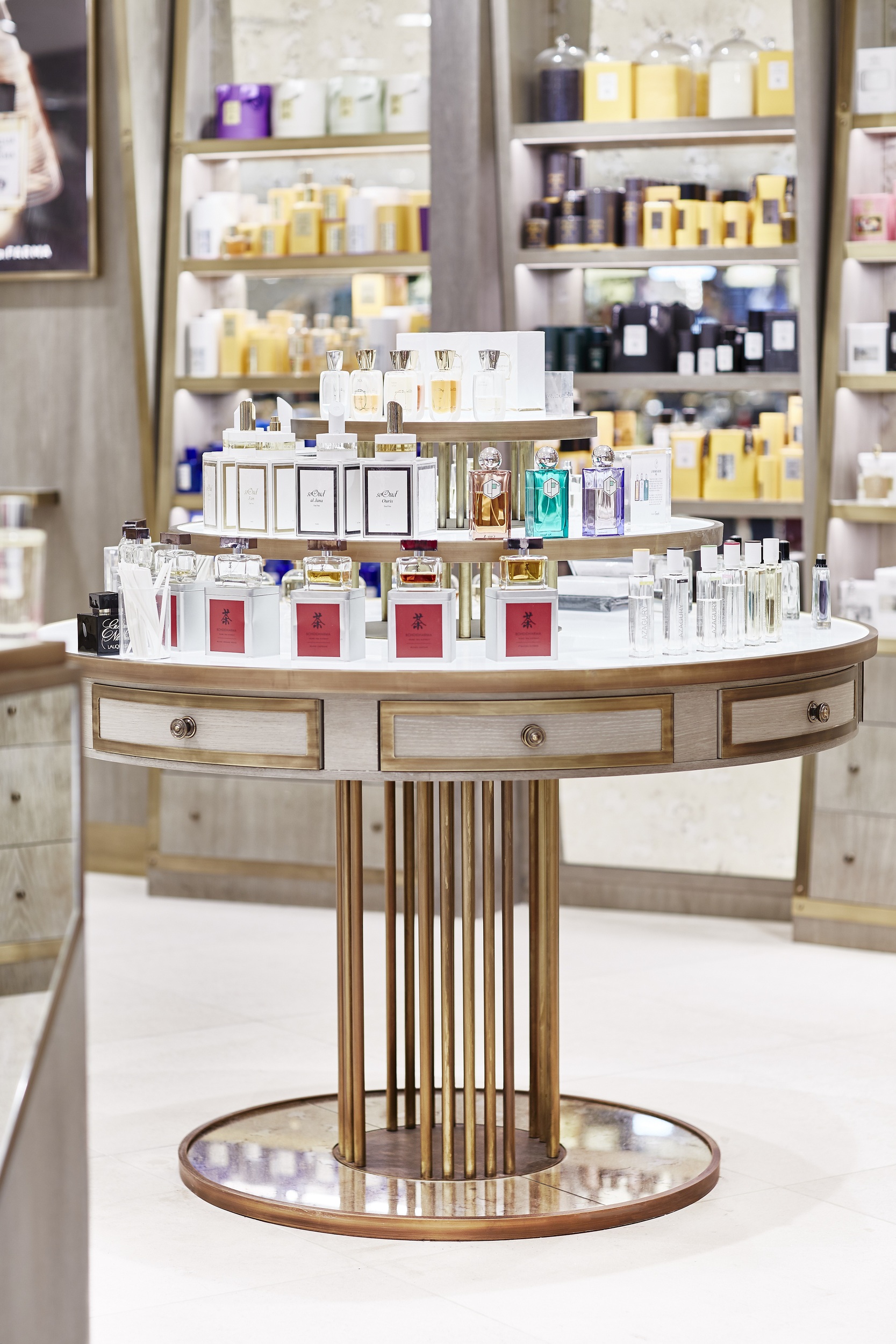 Tiered perfume table with grey timber shelving and brass frame