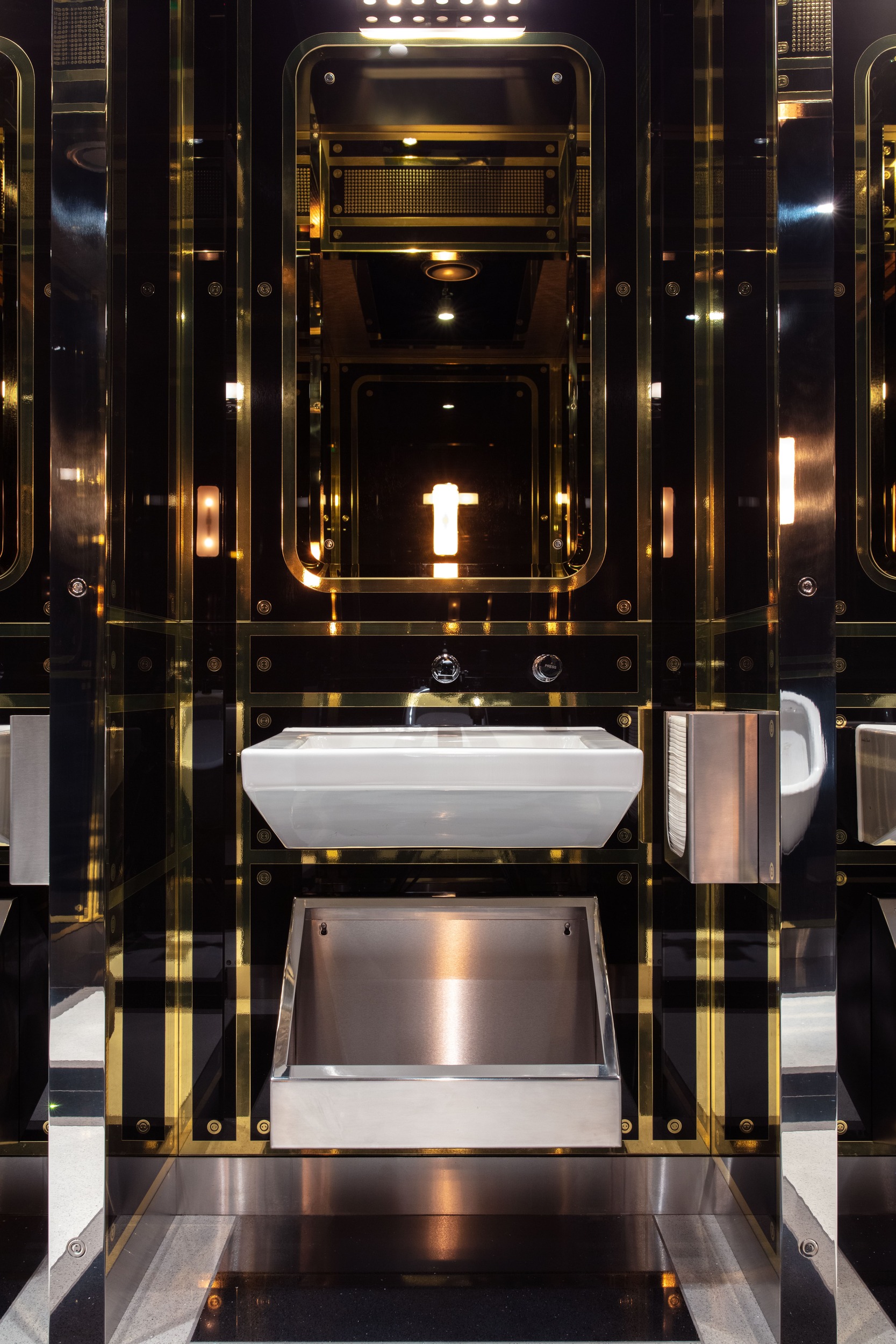 Sophisticated toilet basin with brass trim around mirror and panels