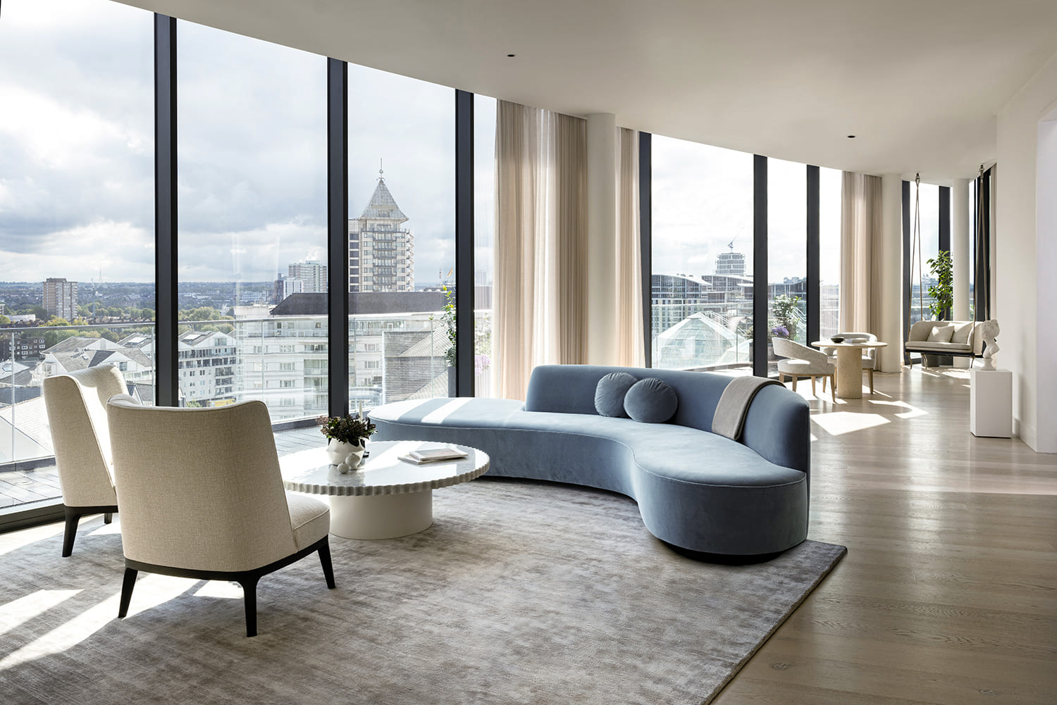 Living area with curved sofa and floor to ceiling windows