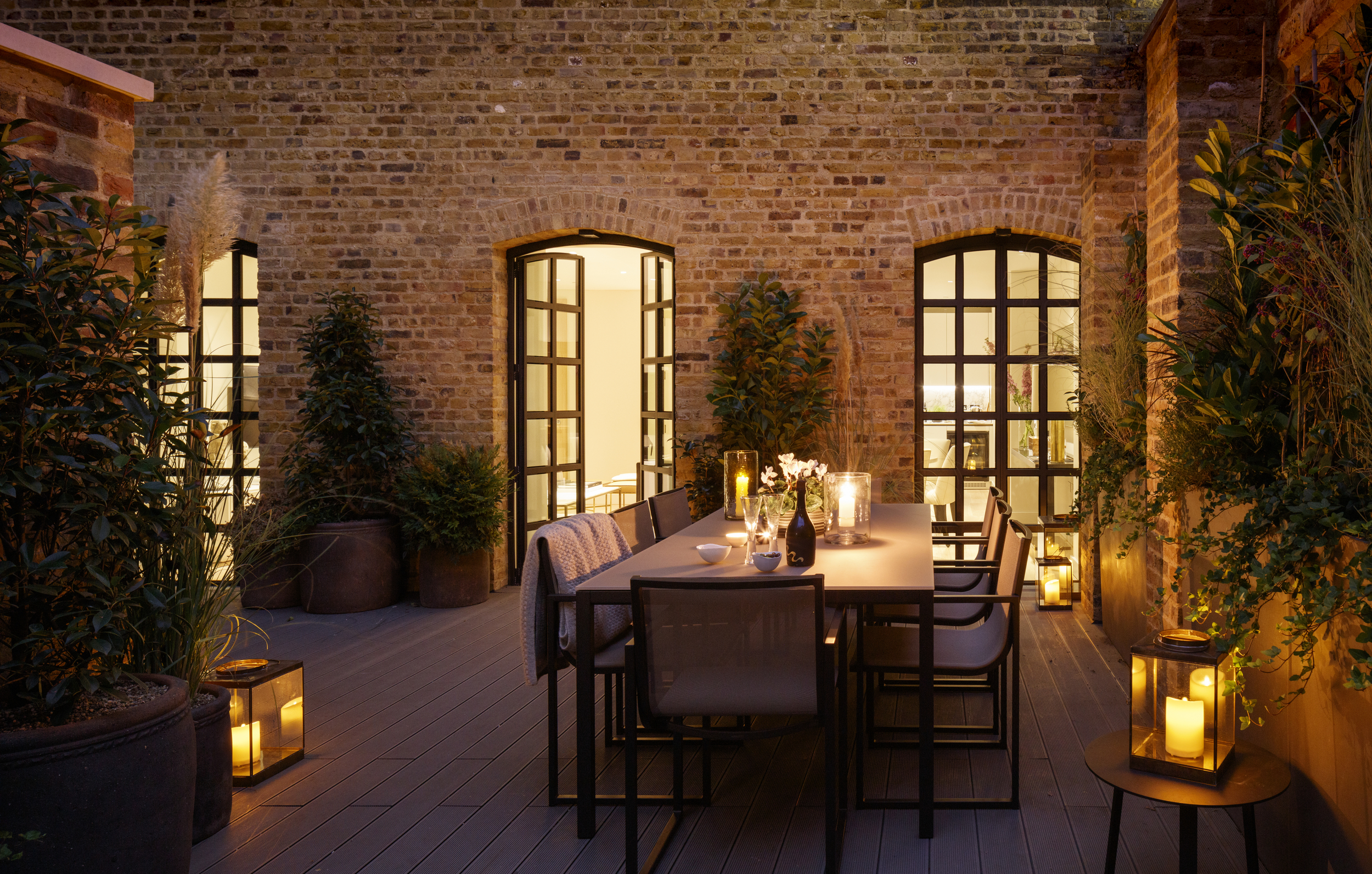 Candle lit outdoor garden with dining set