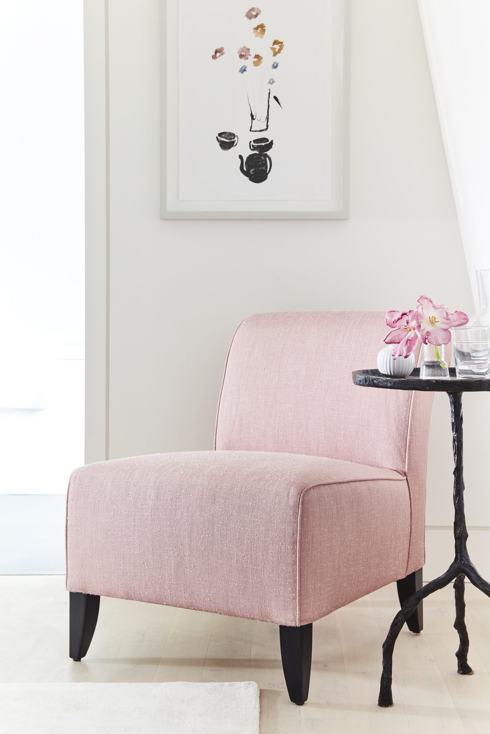 Pink chair with side table and artwork