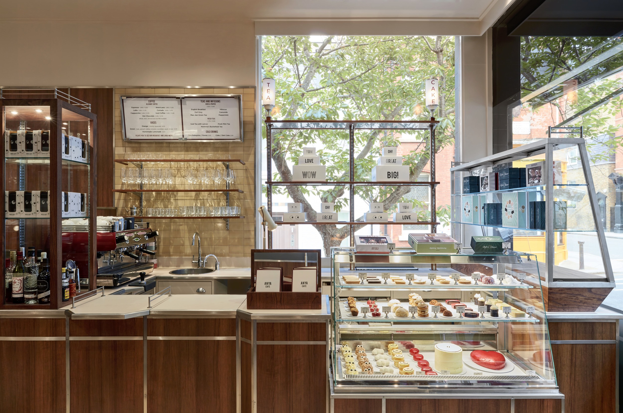 Elegant café counter with picturesque pastry displays and rear shelving