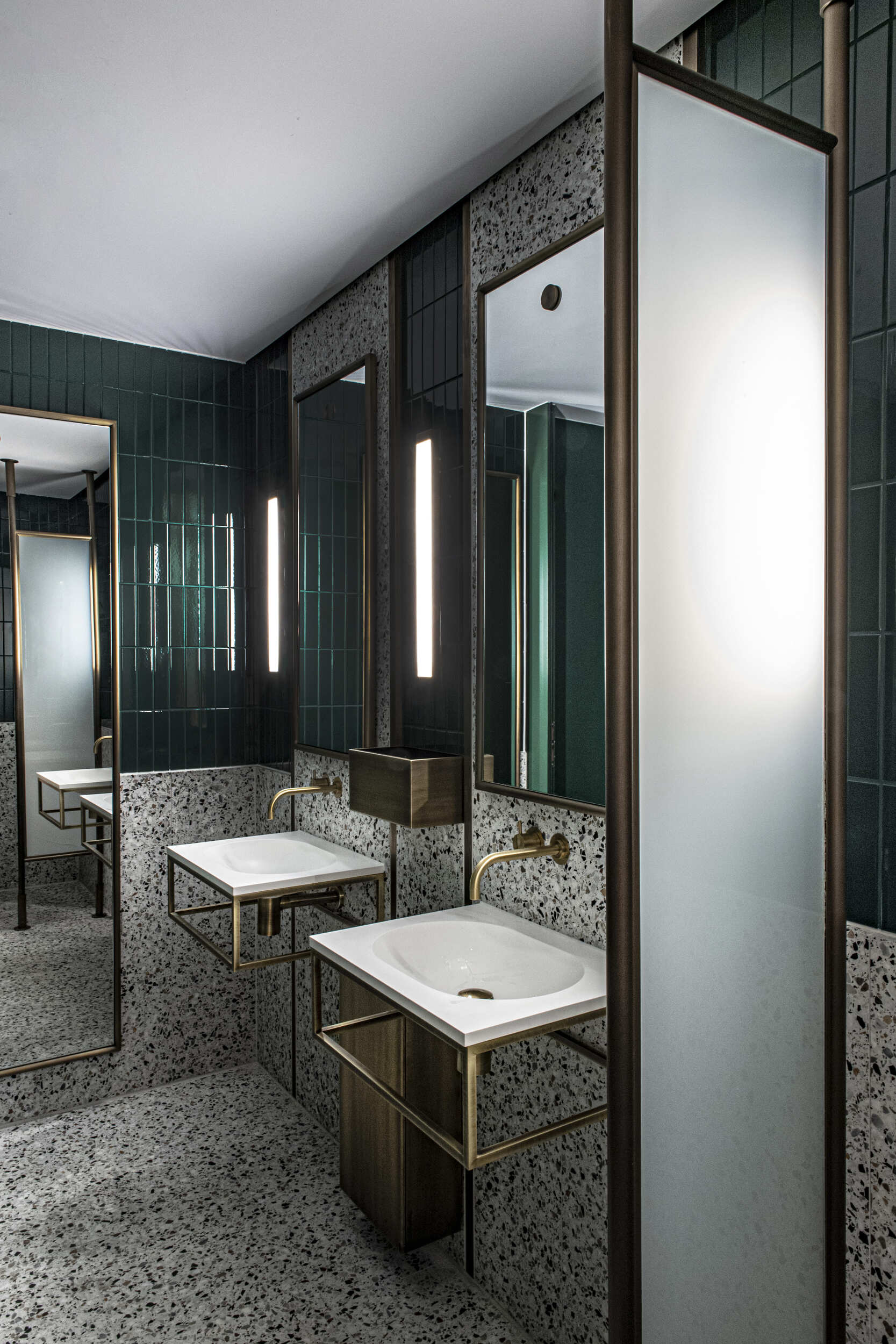 Toilet basins with brass finish and modern wall mounted mirrors