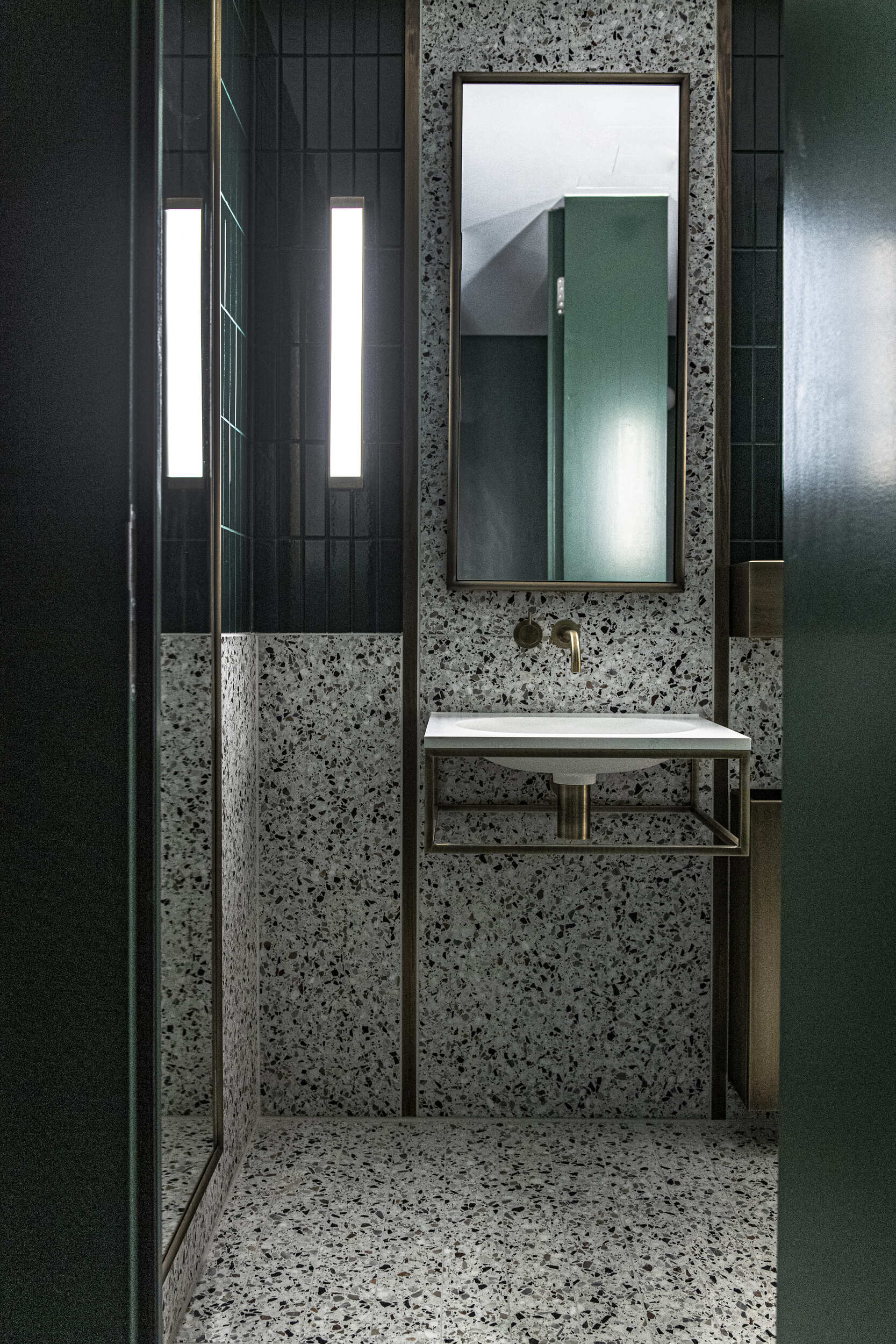 Toilet basin with terrazzo tiles and modern wall mounted mirrors