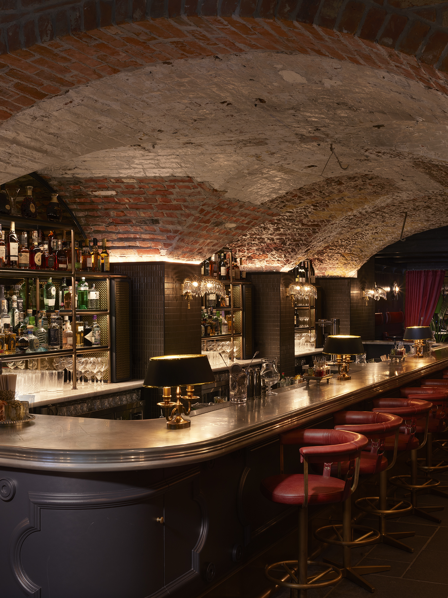 Exposed brick vault bar with marble tops & luxury red bar stools