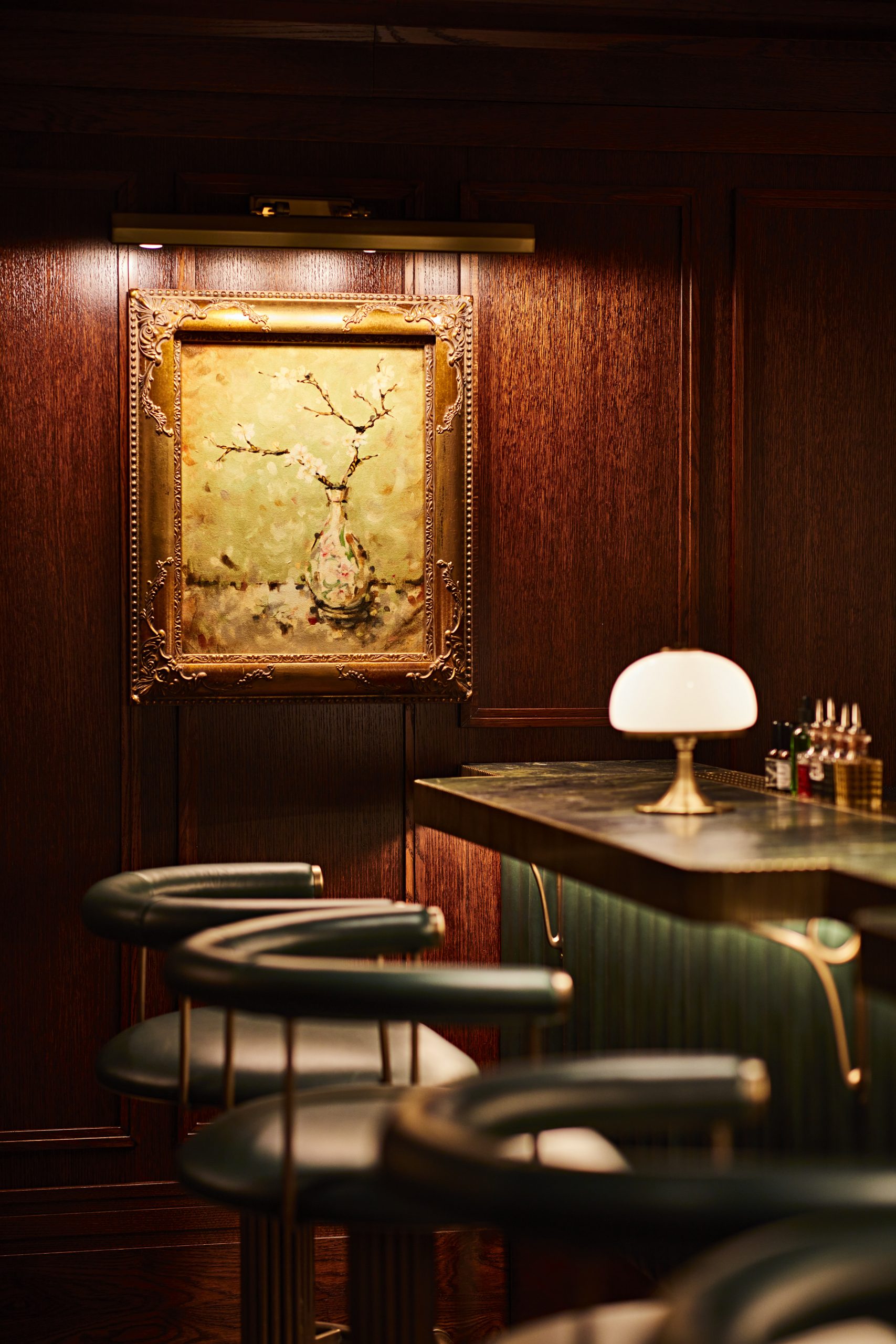 Intimate bar counter, opulent leather chairs, ornate framed artwork