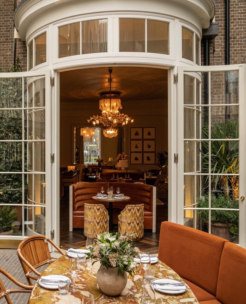 Terrace and drawing room with curved doorway, luxurious chandelier & seating areas