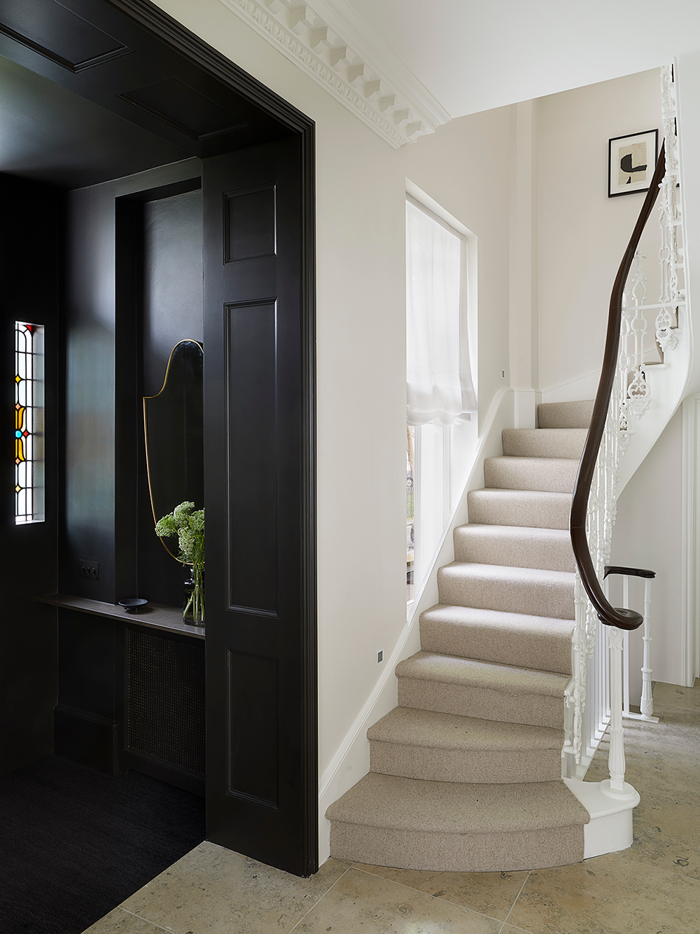 A striking black lobby with stained glass windows leads to a fresh and light hallway